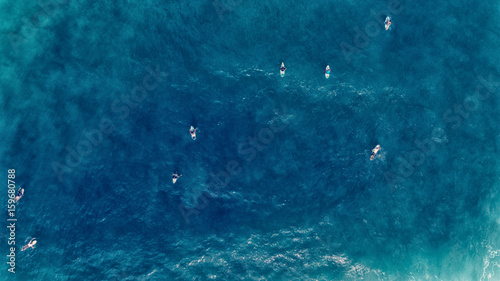 Aerial view of Surfer swimming on board near huge blue ocean wave © wanchai