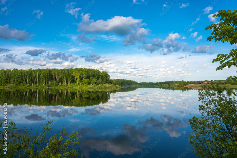 The mirrored surface of the river with reflection of clouds.