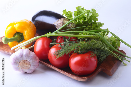 Fresh assorted vegetables, eggplant, bell pepper, tomato, garlic with leaf lettuce. Isolated on white background. Selective focus.