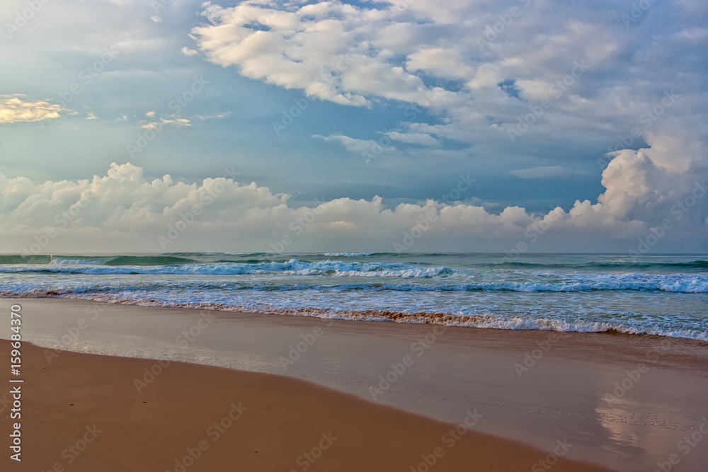 Sandy beach and turquoise ocean waves.