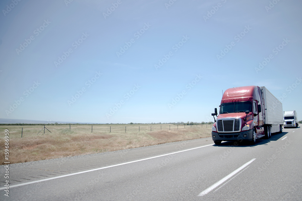 Semi trucks convoy on straight highway on flat plateau Semi trucks convoy on straight highway on flat plateau
