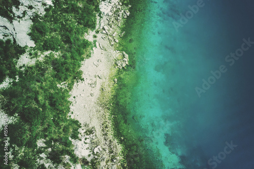 Top view of a rocky seashore with green plants