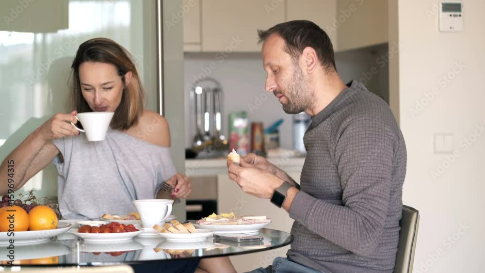 Young couple talking during breakfast at home
Young couple talking during breakfast at home