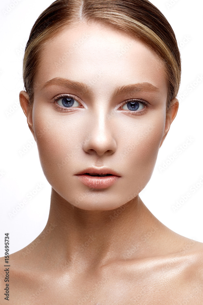 Young girl with perfect shining skin. A beautiful model with a foundation and nude makeup. Clean skin. White isolated background. Beauty of the face. Young girl with perfect shining skin. A beautiful model with a foundation and nude makeup. Clean skin. White isolated background. Beauty of the face.