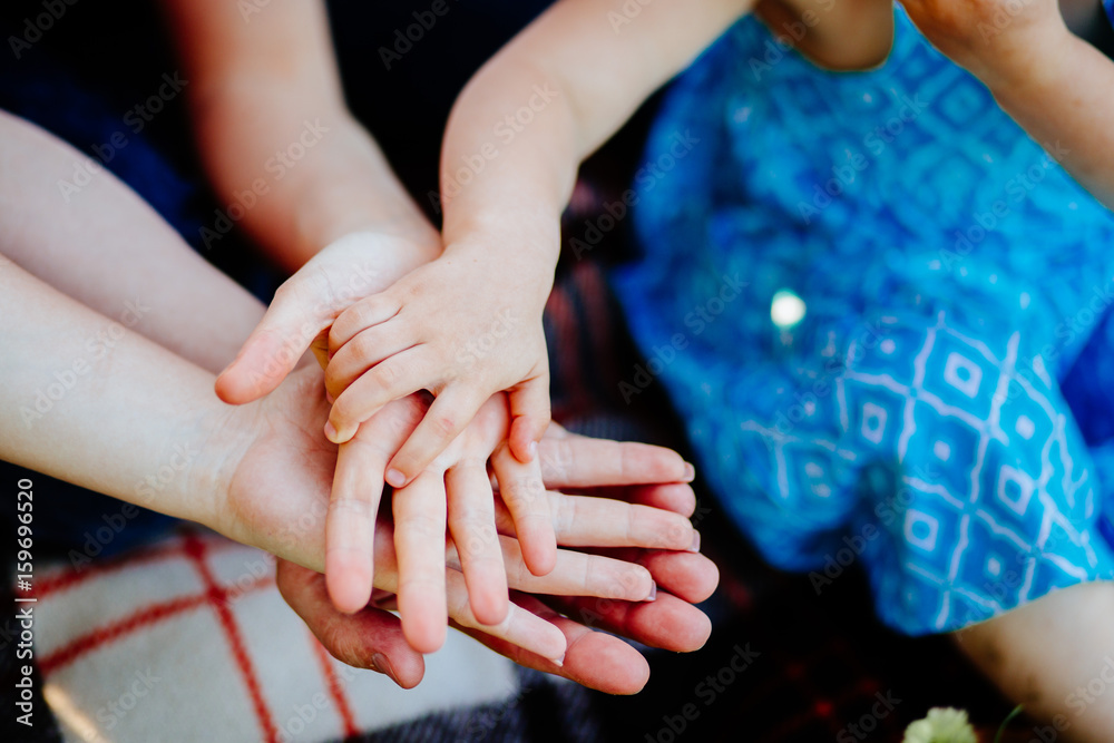 Family of four holding hands one above other. 4 hands. Childhood, love