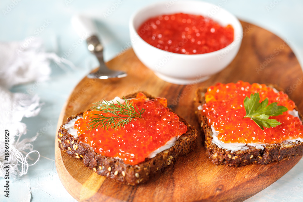 Sandwiches with red salmon caviar and rye bread.