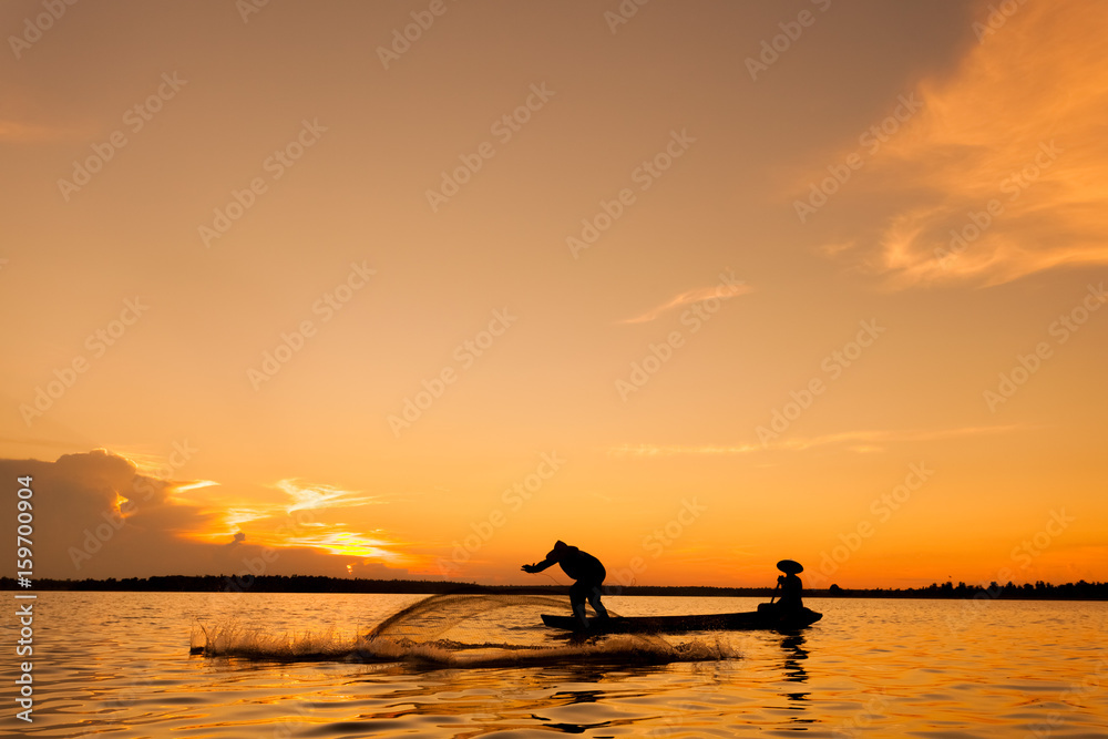 Silhouette,Two fishermen using nets for fishing,sun background 