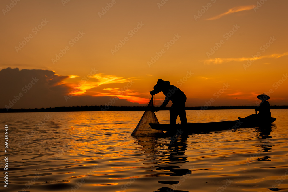 Silhouette,Two fishermen using nets for fishing,sun background 