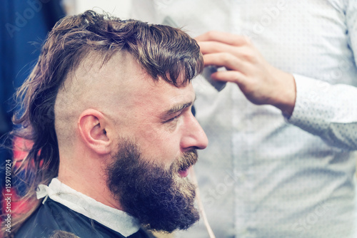 Bearded man with a mohawk in the barbershop photo