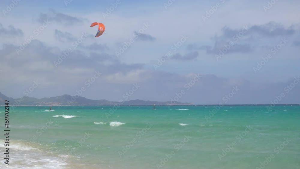 Kitesurfing and WIndsurfing in a Windy Bay in Sardinia Italy Kitesurfing and WIndsurfing in a Windy Bay in Sardinia Italy