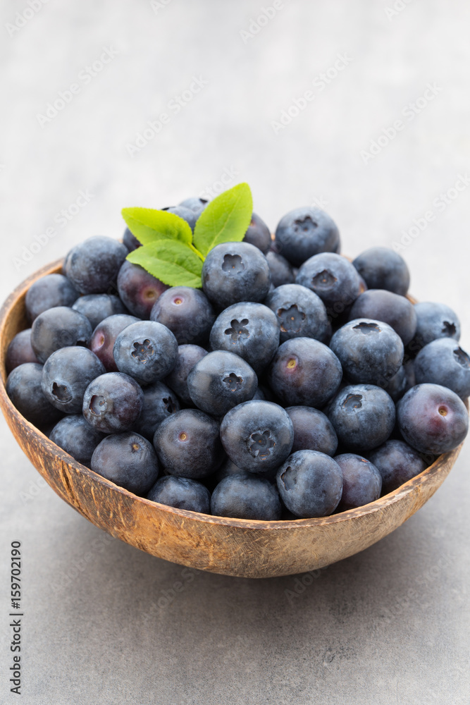 Fresh blueberries natural coconut in a bowl on a gray background.