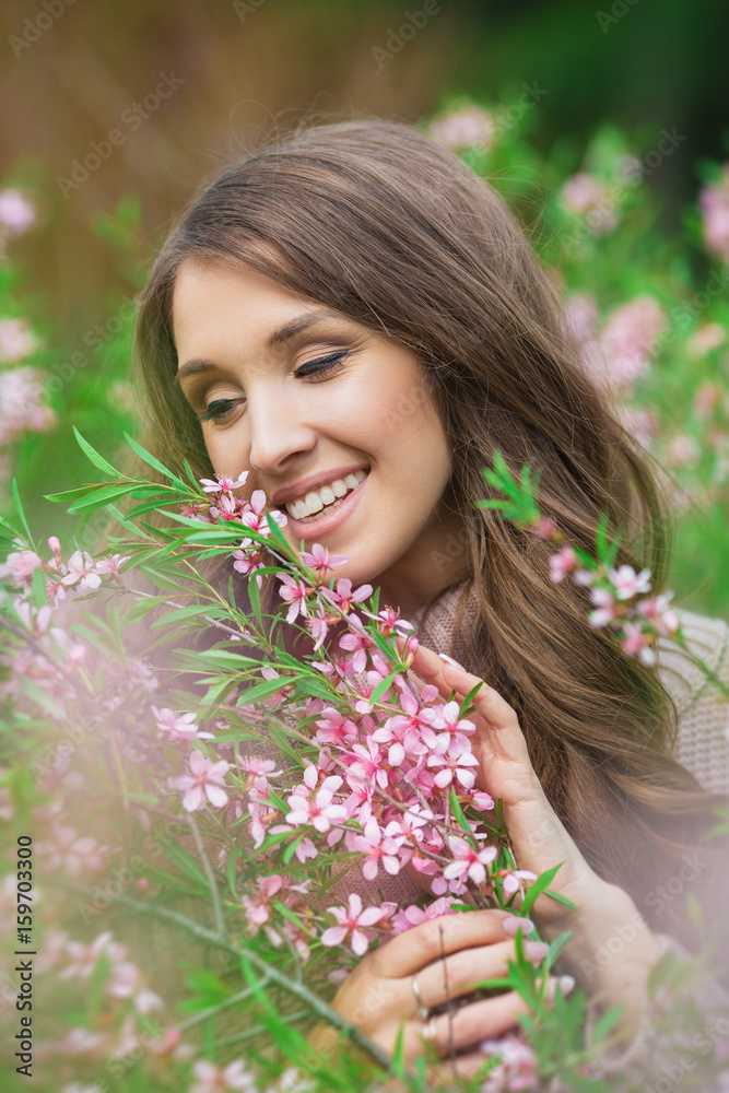 Portrait of smiling young girl with a blooming almond bush Portrait of smiling young girl with a blooming almond bush