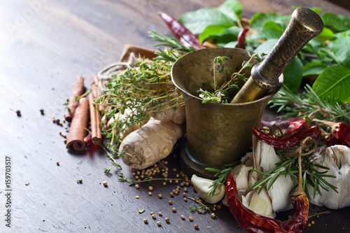 Obraz na plátně Different herbs and spices on a wooden table .