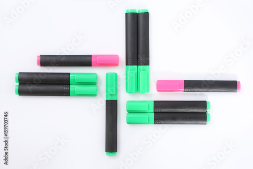 Pink and green markers on a white background