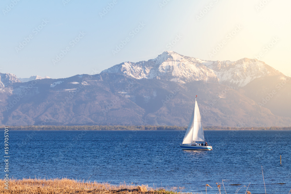 Fototapeta premium Sailing boat on lake chiemsee near Seebruck with lense flares