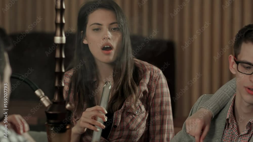 Group of young people smoking hookah in the lounge caffee