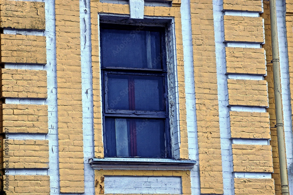 старое окно на коричневой кирпичной стене дома