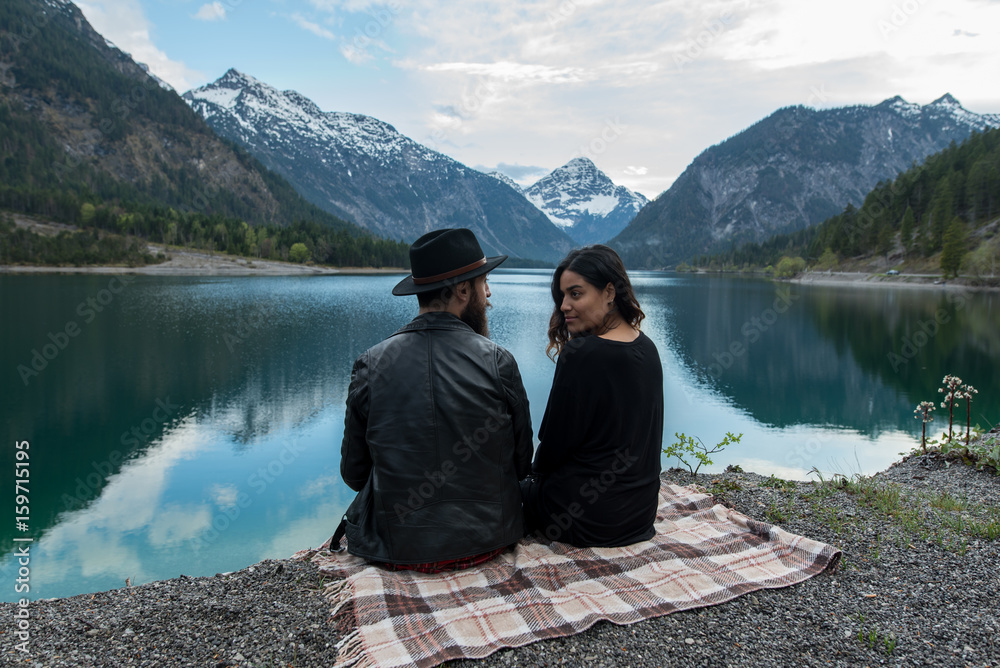 Adventurer couple enjoys nature and mountains in Austria having a picnic