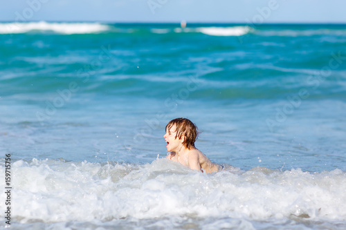 little blond kid boy having fun on ocean beach in Florida © Irina Schmidt