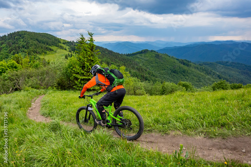 A man is riding bicycle, on the background of mountains