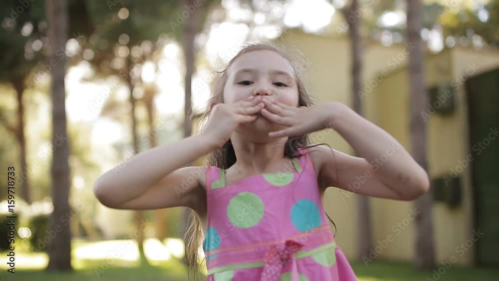 The girl on the nature jumps has fun and sends kisses to the camera The girl on the nature jumps has fun and sends kisses to the camera
