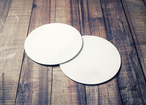 Two blank white beer coasters on vintage wooden table background. Responsive design mockup. photo