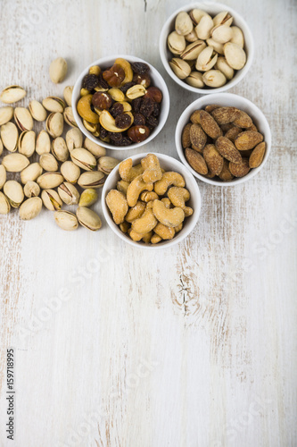 Four bowls with nuts on a wooden table