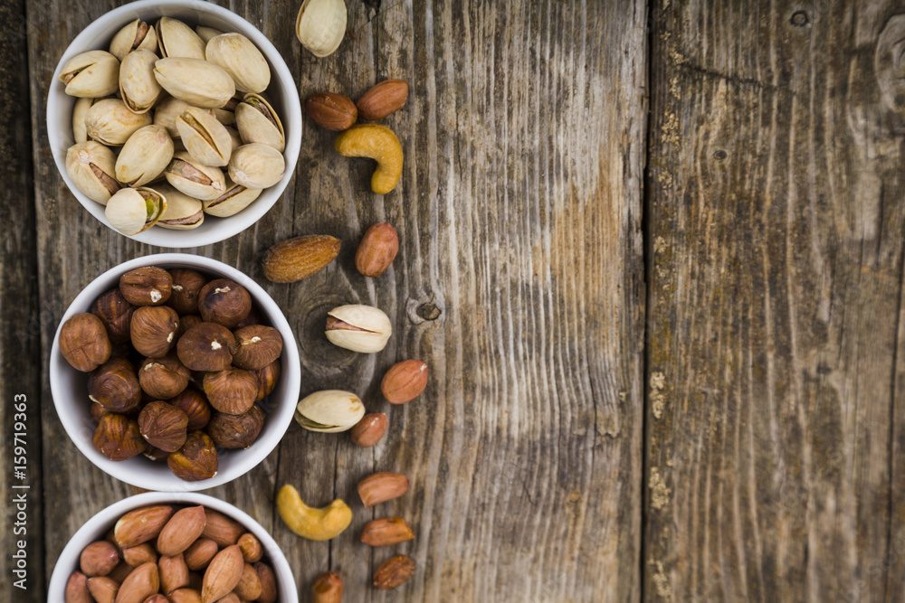 White bowls with nuts on a wooden table White bowls with nuts on a wooden table