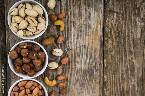 White bowls with nuts on a wooden table