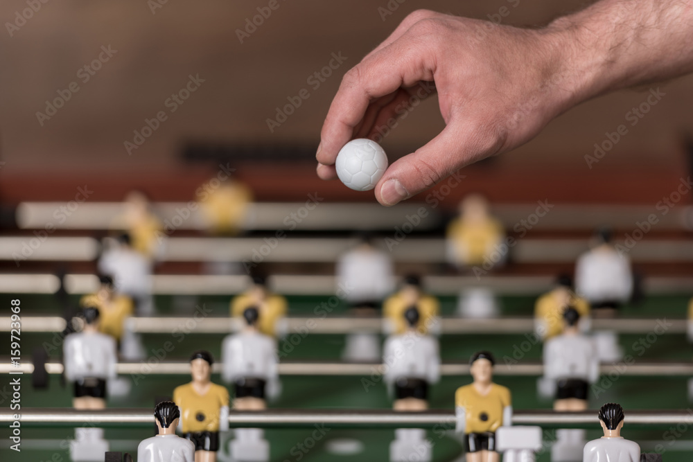 Close-up view of foosball and hand with ball, selective focus Close-up view of foosball and hand with ball, selective focus