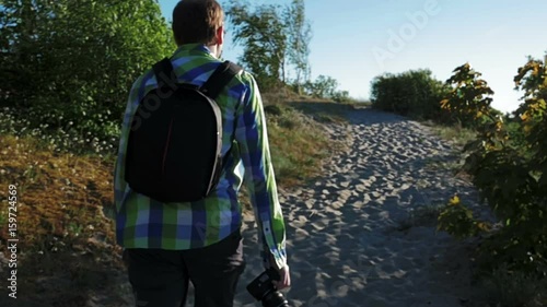 Slow motion, Defocus, Photographer is walking along dunes to sea photo