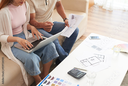 фотографія High angle shot of young couple discussing housing plans and using laptop