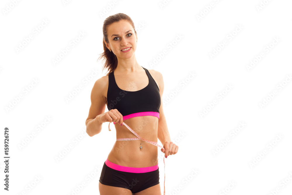 young girl smiling on camera and measure with tape a waist young girl smiling on camera and measure with tape a waist