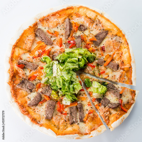 Sliced pizza with beef and salad
