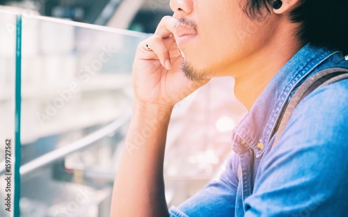 Fototapeta Naklejka Na Ścianę i Meble -  Closeup of asian man in blue jeans shirt is calling, Lifestyle concept