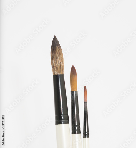 Various artists paint brushes of different sizes and shapes