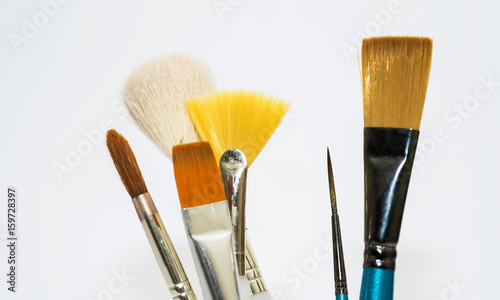Various artists paint brushes of different sizes and shapes