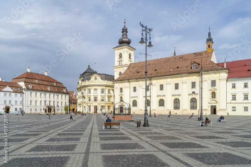 Benches on the famous Piata Mare, Large Square, in a moment of tranquility, Sibiu, Romania, with the Holy Trinity church in the background