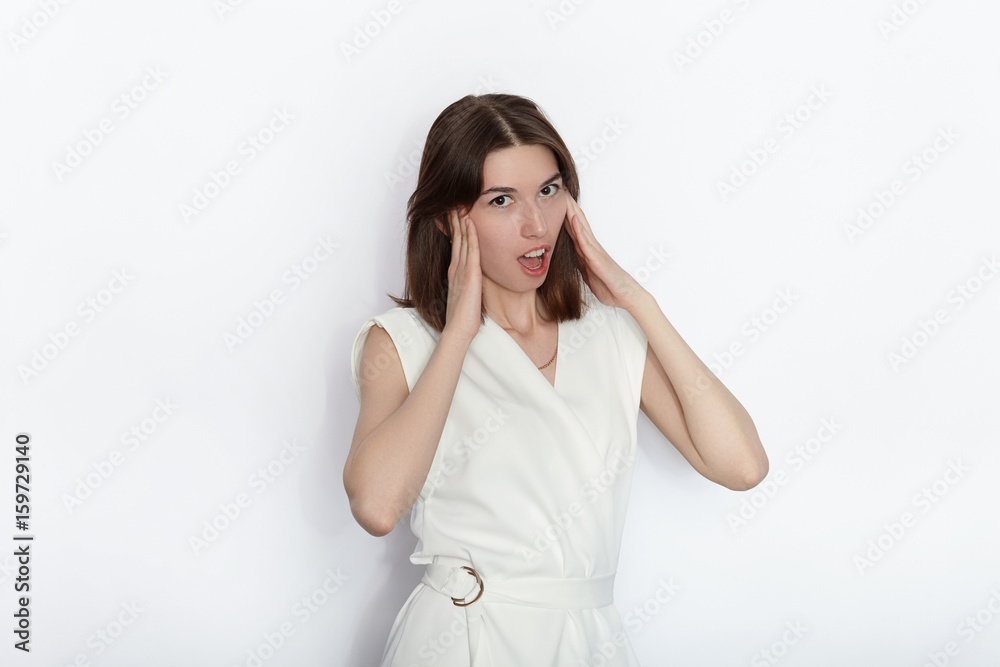 Young beautiful brunette beginner model woman in white blouse practicing posing showing emotions on white wall studio background Young beautiful brunette beginner model woman in white blouse practicing posing showing emotions on white wall studio background