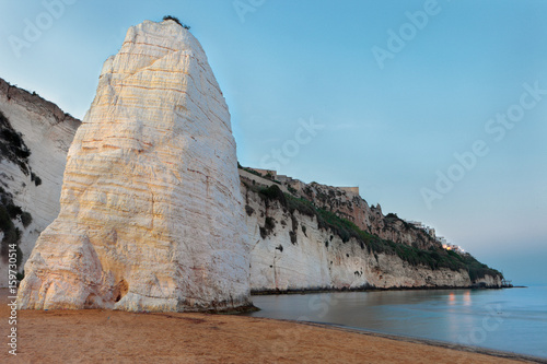 The beach of Pizzomunno with is stone monolith at late sunset, Vieste, Apulia, Italy photo