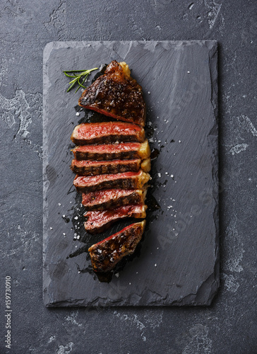 Sliced medium rare grilled Striploin steak on slate board