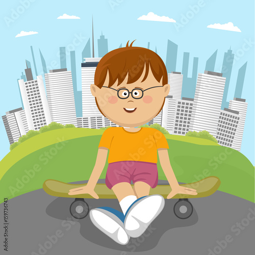Little nerd boy sitting on a skateboard in park in front of downtown