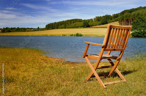 chaise en bois sur les berges d'un lac © coco