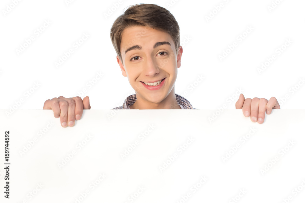 smiling teenage boy holding blank banner isolated on white smiling teenage boy holding blank banner isolated on white