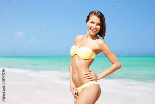 happy woman in bikini posing on summer beach