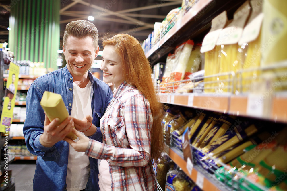 young couple chooses foods at the supermarket