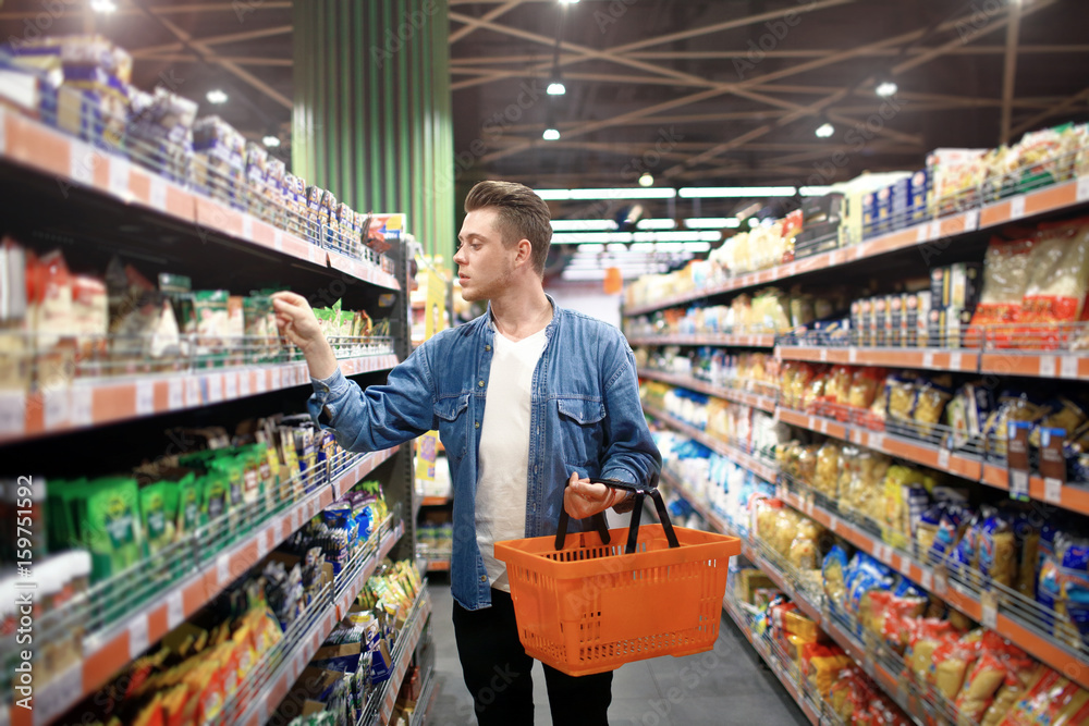 a young man chooses foods at the supermarket