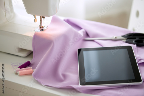 sewing machine  tablet pc  fabric and threads