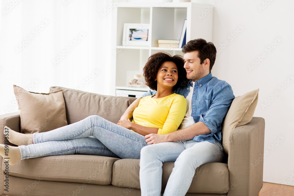 happy smiling international couple on sofa at home happy smiling international couple on sofa at home