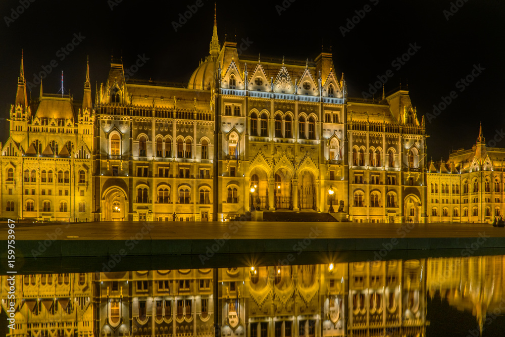 ungarisches beleuchtetes Parlamentsgebäude spiegelt sich in Wasserfläche